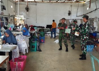 Babinsa Sawit Bantu Petani Desa Manjung dalam Proses Pemupukan Padi